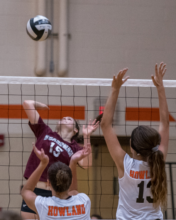 DIANNA OATRIDGE | THE VINDICATOR Boardman's Kaylin Burkey (15) attempts a kill as Howland's Mia Pantalone (left) and Maddie Sisler (right) prepare to block during their match in Howland on Tuesday. The Spartans won 3-0.