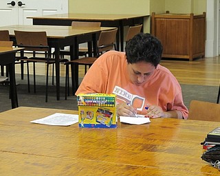 Neighbors | Jessica Harker.Stephanie Ruess used markers to color her page during the Aug. 10 Color Your World event at the Poland library.