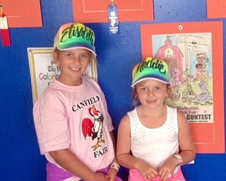 Neighbors | Submitted.Elisabeth and Maddie Facemyer standing next to their winning photos during the Canfield fair.