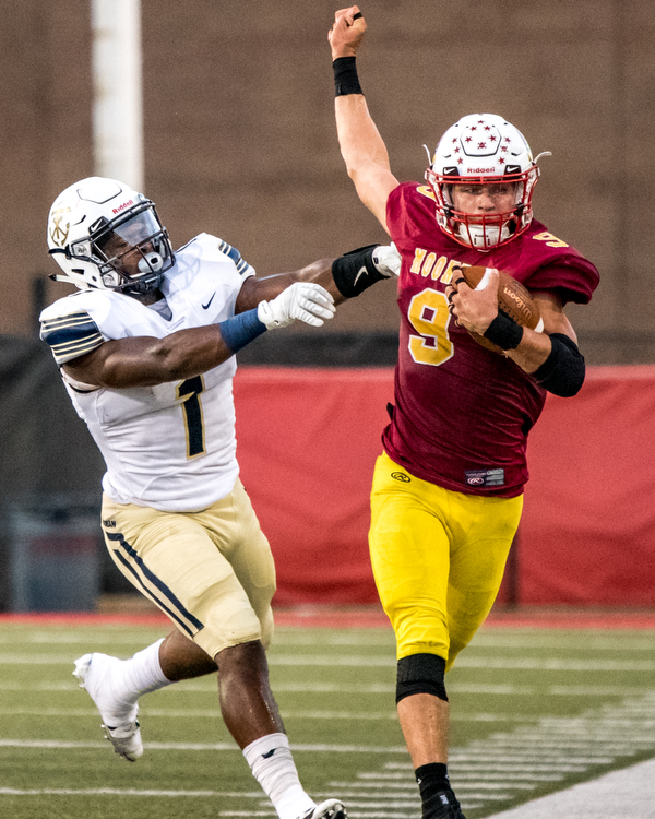 DIANNA OATRIDGE | THE VINDICATORÊ Cardinal Mooney's Jason Santisi gets pushed out of bounds by Akron Hoban's Deamonte Trayanum during their game at Stambaugh Stadium in Youngstown on Friday night.