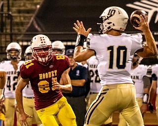 DIANNA OATRIDGE | THE VINDICATORÊ Cardinal Mooney's Anthony Fire pursues Akron Hoban quarterback Shane Hamm during their game at Stambaugh Stadium in Youngstown on Friday night..