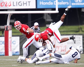 YSU's Tevin McCaster jumps over Butler players during the first half of the game on Saturday.