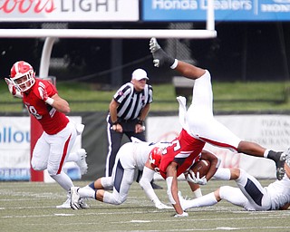 YSU's Tevin McCaster jumps over Butler players during the first half of the game on Saturday.