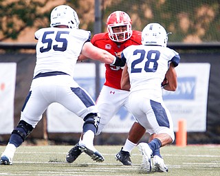 YSU's Wes Thompson attempts to block Butler's John McArthur (55) and Anthony Scaccia during the game on Saturday.