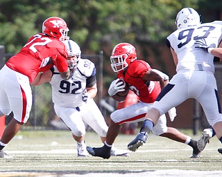 YSU's Charles Baldwin blocks Butler's Matt Hawkins while YSU's Tevin McCaster runs with the ball during the game on Saturday.