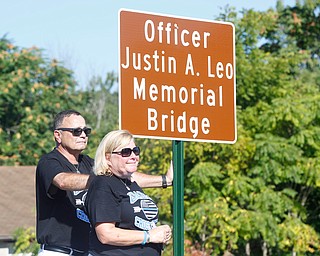 Justin Leo's parents Dave and Pat Leo stand next to the new sign of the bridge after it's unveiled at the dedication ceremony during which The Girard-McDonald viaduct was officially renamed the Officer Justin Leo Memorial Bridge on  Monday morning.