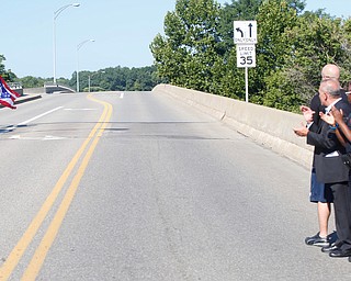 A police motorcycle takes the first ride across the newly named Officer Justin Leo Memorial Bridge at the dedication ceremony in Girard on Monday morning.