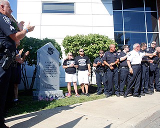 Justin Leo's parents Pat and Dave Leo stand with police officers after the unveiling of a monument in memory of their son outside the entrance to the police department in Girard's City Hall on Monday morning.