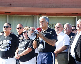 Girard Mayor James Melfi speaks during the dedication ceremony for the Justin A. Leo Memorial Bridge surrounded by Leo's parents, police office, and Girard community members Monday morning.