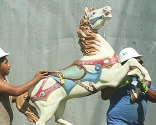 Workers take down amusement rides at the Canfield Fairgrounds on Tuesday.