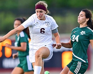 Boardman’s Anna Deeley (6) eludes Ursuline’s Lucia Rohrbaugh (34) while dribbling upfield during the second half of a game on Wednesday night at Youngstown State’s Farmers National Bank Field. Deeley scored three goals and Boardman won, 7-0.