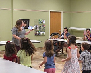 Neighbors | Jessica Harker.Cody Stall, a MetroParks employee, read "Dinosaur Dance," and danced along with the books instructions with the children gathered at the Sprout Club event August 16.