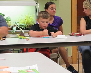 Neighbors | Jessica Harker.A child flattened out play dough to make dinosaur tracks during the August 16 Sprout Club event at the Fellows Riverside Garden.