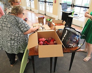 Neighbors | Jessica Harker .Boxes of yarn organized by color were available to project participants to use during the pompom door hanger making event August 20 at the Poland library.
