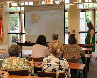 Neighbors | Jessica Harker .Event participants watch a video explaining how to make and use a pompom maker during the Summer Pompom Doorhanger making event August 20 at the Poland library.