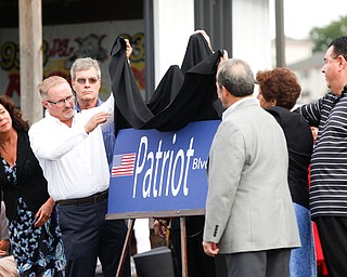 A sign for the renamed Patriot Boulevard, formerly Interstate Boulevard, is unveiled at the Austintown Patriot Day ceremony outside of Quaker Steak and Lube in Austintown on Thursday. EMILY MATTHEWS | THE VINDICATOR