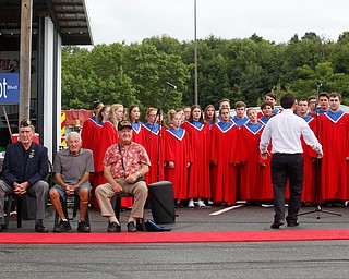 The Austintown Fitch High School concert choir sings while, from left, Joe Brown, a U.S. Army veteran of Vietnam, Charles Jaros, a U.S. Army veteran of Vietnam, James Kenneally, a U.S.M.C veteran of Korea, and Roy Gallatin, a U.S.M.C veteran of World War ||, four of the 13 veterans honored at the Austintown Patriot Day ceremony, listen in front of them outside of Quaker Steak and Lube in Austintown on Thursday. EMILY MATTHEWS | THE VINDICATOR