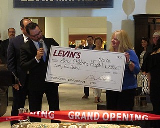 Neighbors | Jessica Harker.Chris Pelcher awarded a check for $2,500 to the Akron Childrens Hospital's Beeghly Campus during the ribbon cutting opening ceremony August 31.