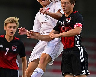 CANFIELD, OHIO - SEPTEMBER 6, 2018: Fitch's Dom Foley heads the ball away from Canfield's Mitch Mangle during the first half of their game, Thursday night at Canfield High School. DAVID DERMER | THE VINDICATOR