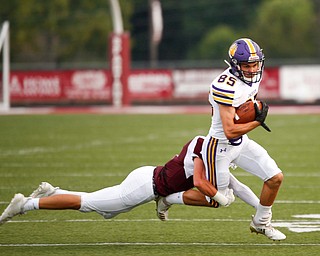 Jackson's Preston Johnson runs with the ball as Boardman's Mike Fesko tackles him during the first half of their game Friday night at Boardman. EMILY MATTHEWS | THE VINDICATOR