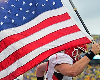 MORGANTOWN, WEST VIRGINIA - SEPTEMBER 8, 2018: Youngstown State's Montgomery VanGorder runs onto the field with the American flag before the start of Saturday nights game against West Virginia. DAVID DERMER | THE VINDICATOR