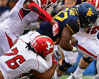 MORGANTOWN, WEST VIRGINIA - SEPTEMBER 8, 2018: West Virginia's Martell Pettaway is tackled by Youngstown State's Lamont Ragland and Cash Mitchell during the first half of their game, Saturday night. DAVID DERMER | THE VINDICATOR