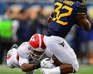 MORGANTOWN, WEST VIRGINIA - SEPTEMBER 8, 2018: West Virginia's Martell Pettaway is tackled by Youngstown State's Avery Larkin during the first half of their game, Saturday night. DAVID DERMER | THE VINDICATOR