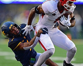 MORGANTOWN, WEST VIRGINIA - SEPTEMBER 8, 2018: Youngstown State's Zach Farrar is tackled by West Virginia's Derek Pitts Jr. during the first half of their game, Saturday night. DAVID DERMER | THE VINDICATOR