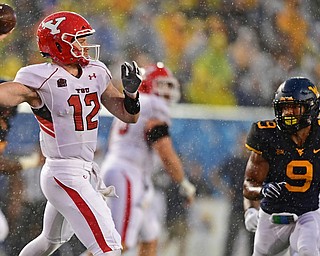 MORGANTOWN, WEST VIRGINIA - SEPTEMBER 8, 2018: Youngstown State's Montgomery VanGorder throws a pass while being pressured by West Virginia's JoVanni Stewart during the first half of their game, Saturday night. DAVID DERMER | THE VINDICATOR