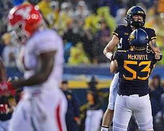 MORGANTOWN, WEST VIRGINIA - SEPTEMBER 8, 2018: West Virginia's Will Grier celebrates with Colton McKivitz after throwing a touchdown pass during the first half of their game, Saturday night. DAVID DERMER | THE VINDICATOR