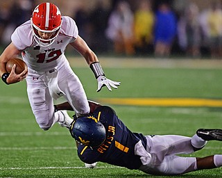 MORGANTOWN, WEST VIRGINIA - SEPTEMBER 8, 2018: Youngstown State's Montgomery VanGorder is tackled by West Virginia's Derek Pitts Jr. during the second half of their game, Saturday night. West Virginia won 52-17. DAVID DERMER | THE VINDICATOR