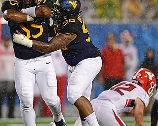 MORGANTOWN, WEST VIRGINIA - SEPTEMBER 8, 2018: West Virginia's Dante Stills celebrates while being congratulated by Darius Stills after sacking Youngstown State's Montgomery VanGorder during the second half of their game, Saturday night. West Virginia won 52-17. DAVID DERMER | THE VINDICATOR