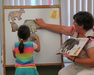 Neighbors | Jessica Harker.Norah Chasko placed cut outs of a sheep and two lambs on the magnetic board during the story telling portion of the playtime event on August 15.