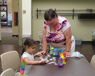 Neighbors | Jessica Harker.Karen Saunders, childrens librarian at the Boardman branch, helped Norah Chasko work at a rhyming words station during the monthly play time event August 15.