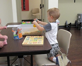 Neighbors | Jessica Harker.Collin Chasko used pinchers to pull different numbers from a bin full of pasta and place them in the right spot on the board for the Boardman libraries monthly playtime event August 15.