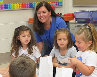 Neighors | Jessica Harker .Teacher Diana Weaver listened as Elaina Patsko shared a picture of her family from her "me bag" Sept. 7 at Poland Union Elementary's preschool.