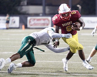 Cardinal Mooney's Dom Byrd tries to get past St. Vincent-St. Mary's Dalen Peeks during the first half of their game at Stambaugh Stadium on Friday night. EMILY MATTHEWS | THE VINDICATOR