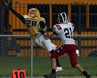 YOUNGSTOWN, OHIO -September 14, 2018: NILES RED DRAGONS vs YOUNGSTOWN EAST GOLDEN BEARS at Rayen Stadium- East Golden Bears' Marquan Herron (28) makes a one handed catch as Niles Red Dragons' Doug Foster (21) defends during the 2nd qtr.  MICHAEL G. TAYLOR | THE VINDICATOR