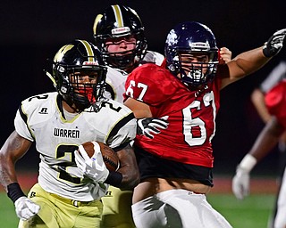 AUSTINTOWN, OHIO - SEPTEMBER 14, 2018: Harding's Kayron Adams runs away from Fitch's Jason Valentin during the first half of their game, Friday night at Austintown Fitch High School. DAVID DERMER | THE VINDICATOR