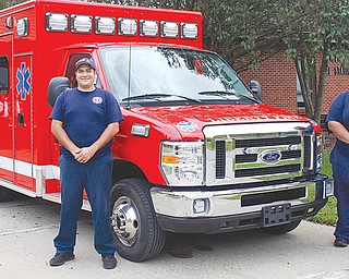 Ronald Womack, left, of Liberty, and Ronnie Simone, of Warren, fi refi
ghters with the Liberty Township Fire Department, stand next to
the township’s new ambulance parked in front of the fi re station.