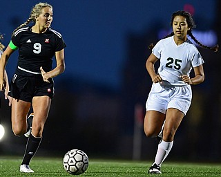 YOUNGSTOWN, OHIO - SEPTEMBER 19, 2018: Mooney's Lexi Saunders, left, runs ahead of Ursuline's Spring Limbu during Wednesday nights game at the Youngstown State Soccer complex. DAVID DERMER | THE VINDICATOR