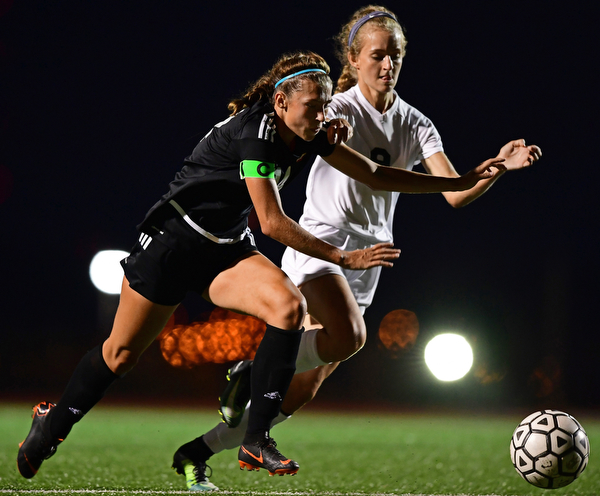 YOUNGSTOWN, OHIO - SEPTEMBER 19, 2018: Mooney's Bre Evans, left, battles with Ursuline's Caroline Aey during Wednesday nights game at the Youngstown State Soccer complex. DAVID DERMER | THE VINDICATOR