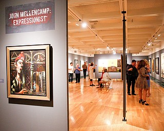 People look at different pieces of art by John Mellencamp during the reception of the exhibit John Mellencamp: Expressionist at The Butler Institute of American Art on Thursday. EMILY MATTHEWS | THE VINDICATOR