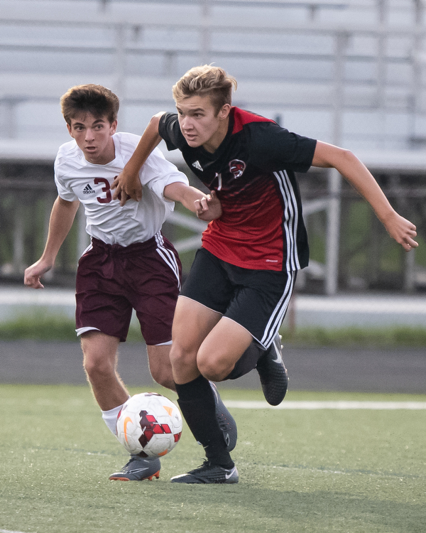 DIANNA OATRIDGE | THE VINDICATOR Boardman's Jake Hughes (36) and Canfield's Aren Villano(7) pursue the ball during their game at Bob Dove Field in Canfield on Thursday. The Spartans won the AAC match up 4-1.