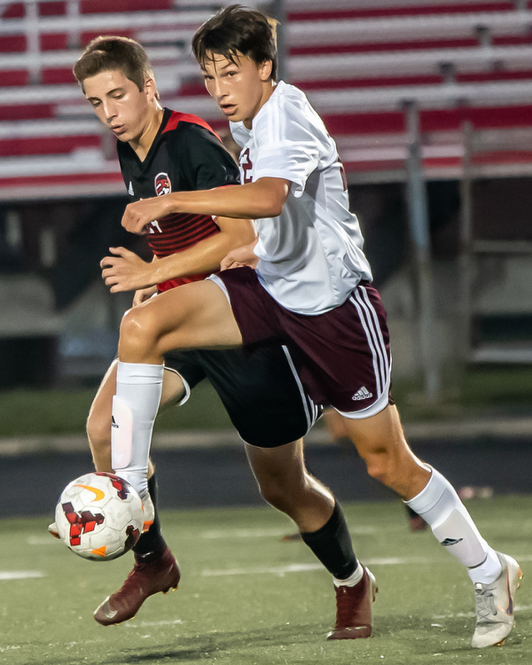 DIANNA OATRIDGE | THE VINDICATOR Boardman's Alexander Wood looks to pass to a teammate under pressure from Canfield's Mitch Mangie during their game at Bob Dove Field in Canfield on Thursday. The Spartans won the AAC match up 4-1.