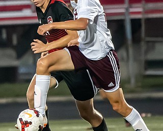 DIANNA OATRIDGE | THE VINDICATOR Boardman's Alexander Wood looks to pass to a teammate under pressure from Canfield's Mitch Mangie during their game at Bob Dove Field in Canfield on Thursday. The Spartans won the AAC match up 4-1.