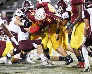 Cardinal Mooney's Jason Santisi gets tackled by Boardman during the first half of their game at Stambaugh Stadium on Friday. EMILY MATTHEWS | THE VINDICATOR