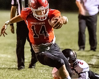 DIANNA OATRIDGE | THE VINDICATOR Struthers' Aiden Hall (14) gets tripped up by Canfield's Cole Morell (2) during their game at  Laddie J. Fedor Field in Struthers on Friday night.