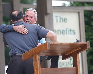 Gino Zimmer, right, the father of Nicholaus E. Zimmer, of the U.S. Army who lost his life in Kufa, Iraq in 2004, hugs Angelo Nuzzo, the events coordinator of Ohio Flags of Honor, at the closing ceremonies for the traveling memorial Sunday. EMILY MATTHEWS | THE VINDICATOR