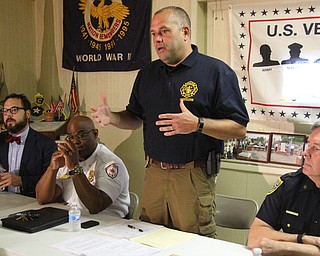 Kurt Wright, Youngstown Fire Department arson investigator, addresses a crowd during a community meeting at the Catholic War Veterans hall on the West Side to address recent arsons in the city. Also on the panel were, from left, Mike Ray, 4th Ward councilman; Barry Finley, Youngstown Fire Chief; and Robin Lees, police chief. 
